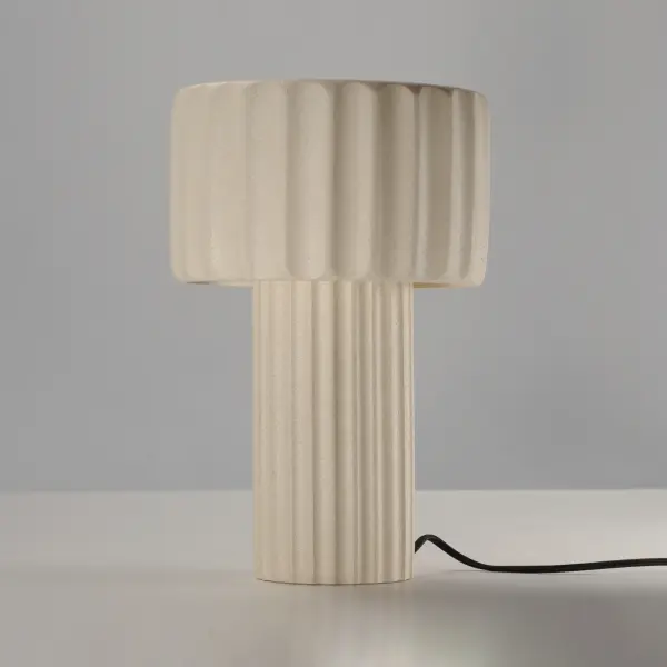 The Delphi Table Lamp merges classical Western design with contemporary materials through its distinctive fluted concrete construction. The chalky white sandstone finish creates ambient lighting perfect for modern workspaces. - alternate view