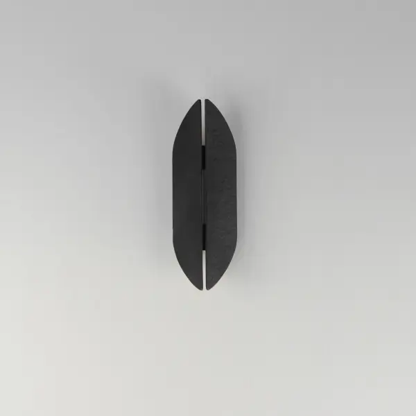 The Tectonic sconce combines architectural drama with functional outdoor lighting. Its textured panels create an enigmatic split design that casts soft ambient light up, down, and through the center crevice. ADA compliant and energy-efficient LED. - alternate view