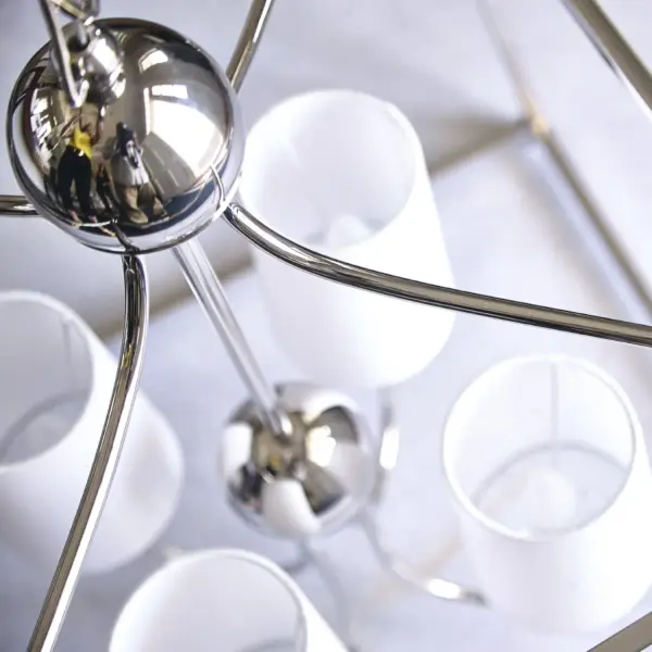 The Libby Langdon-designed Sylvan chandelier combines open-air construction with sophisticated metal detailing. Its 21.5-inch frame creates visual spaciousness while delivering classic elegance in a versatile Black Forged finish. - alternate view