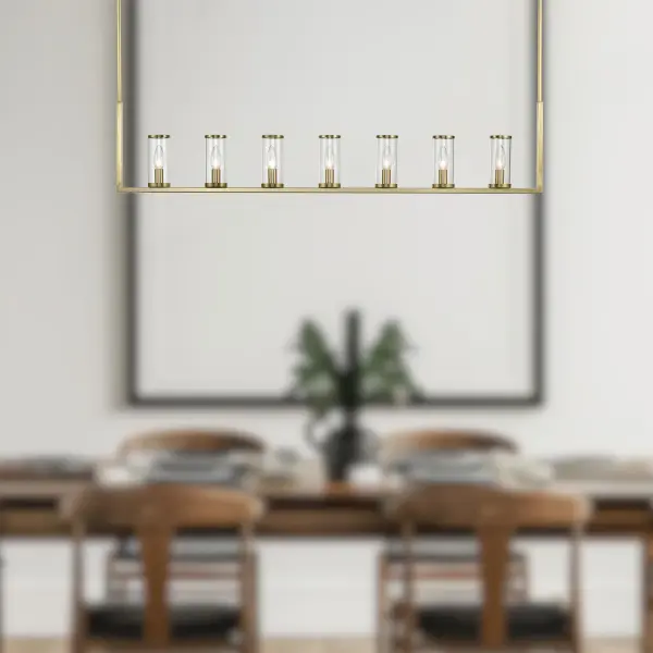 The Revolve 47-inch linear pendant brings timeless elegance to dining and kitchen spaces with its antique candle-holder inspired design. Clear glass tubes accented with metal rings create a striking focal point in transitional interiors. - alternate view