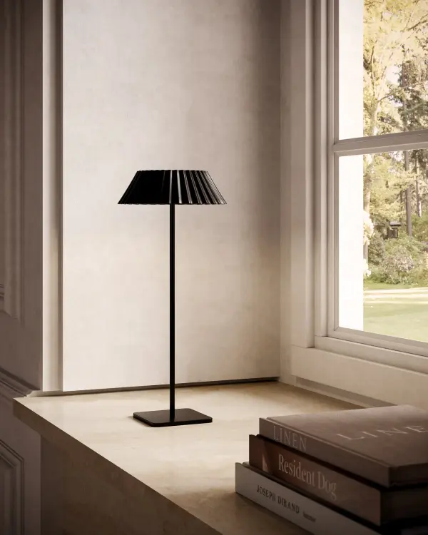 The Pela combines contemporary style with practical convenience. Its distinctive flared, pleated metal shade creates visual interest while the integrated LED and hold-to-dim function offer customizable lighting. The rechargeable battery eliminates cord clutter, making it perfect for flexible placement throughout your home. - alternate view