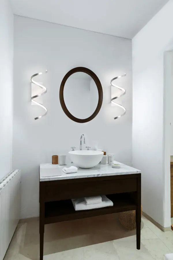 The Synergy wall sconce features a distinctive looping aluminum extrusion with integrated LED lighting that creates a continuous radiant path. Its rolled rectangular form with silicon opal lens delivers soft, even illumination. - alternate view