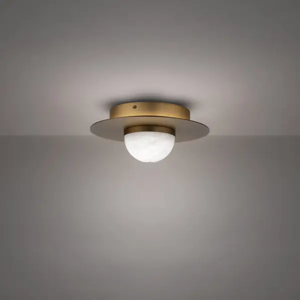 The Landed flush mount combines natural Spanish alabaster with aged brass for a sophisticated, celestial glow. Its compact 12" profile and high CRI LED delivers warm, flattering light ideal for intimate spaces.