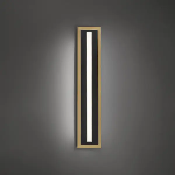 The Lyrikal wall sconce combines minimalist design with functional lighting. Its tall, narrow profile features a thick glass bar balanced by crisp metal in black and aged brass, creating a striking vertical statement.