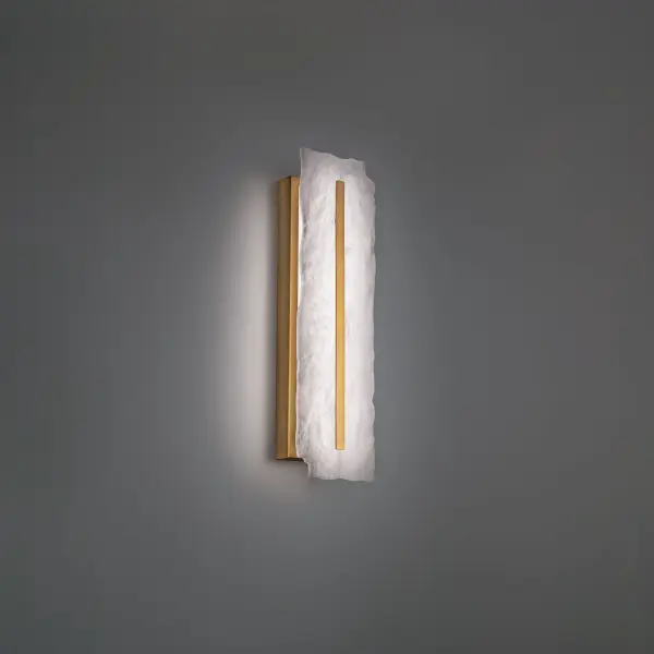 The Taffeta wall sconce showcases a stunning ruffled transparent quartz panel that creates a sophisticated, multi-faceted glow. Its warm 3000K LED light filters beautifully through the translucent stone, while the aged brass finish adds timeless elegance.