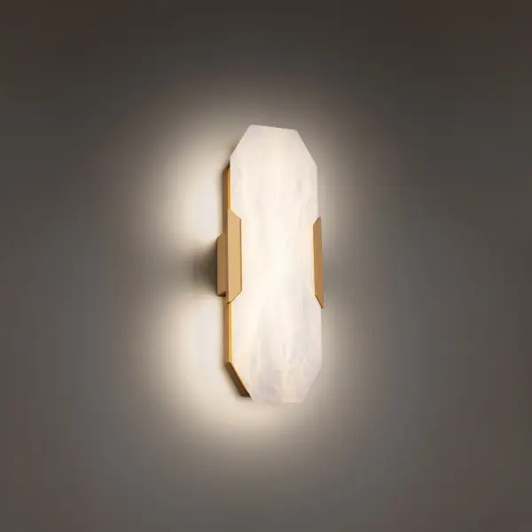 The Toulouse wall sconce combines carved alabaster with aged brass accents for a luxurious, refined aesthetic. Its diffused LED lighting creates warm ambiance while the natural stone variations ensure each piece is unique.