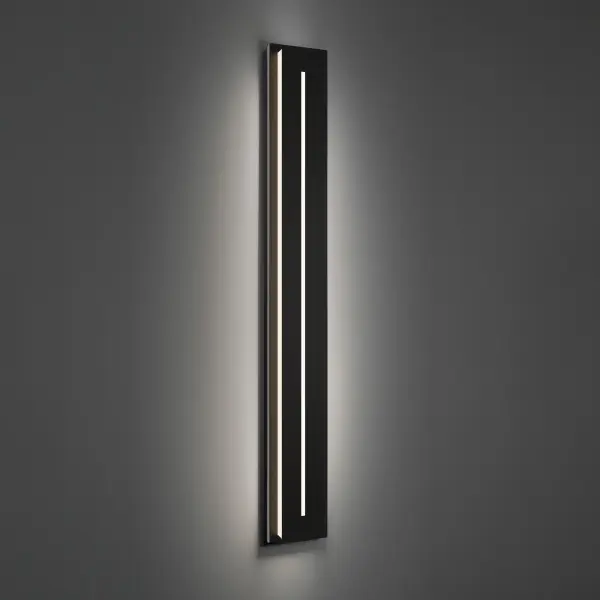 The Midnight outdoor wall sconce delivers dramatic architectural lighting with its 56-inch vertical profile. High-output LED illumination (6165 lumens) casts through mitered glass edges, creating visual interest on facades while providing ample ambient light.