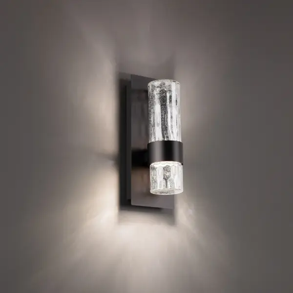 The Beacon outdoor wall sconce combines contemporary minimalism with artisanal glass craftsmanship. Its hammered seeded glass creates a rain-like texture that diffuses LED light beautifully while the durable aluminum construction ensures long-lasting performance.