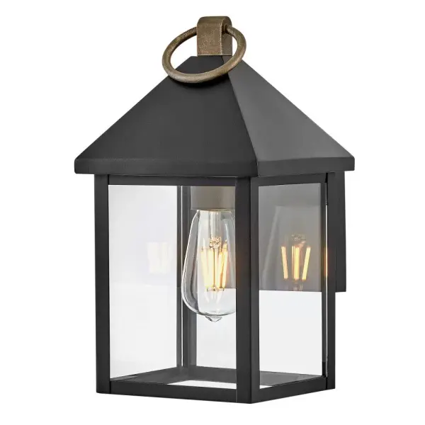 The Rhett Small Wall Lantern combines classic lantern design with modern sensibility. Tall glass panes under a distinctive pyramid roof create architectural interest, while the Black and Burnished Bronze finish adds sophisticated contrast.