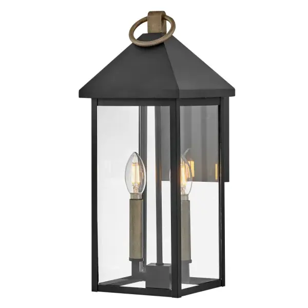 The Rhett wall lantern combines classic lantern design with modern sensibility. Its pyramid roof and tall glass panes create a sophisticated silhouette, while the Black and Burnished Bronze finish adds depth and character.