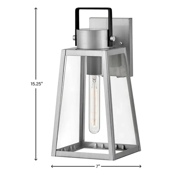 The Hugh outdoor wall lantern delivers sophisticated transitional design with its trapezoidal silhouette and oversized clear glass panes. Two-tone metal finishes add contemporary flair while vintage filament bulbs enhance its visual impact. - alternate view