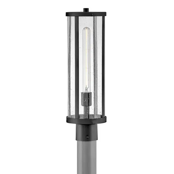 The Alfie post mount lantern combines timeless cylindrical design with clear seedy glass for effortless outdoor style. Its medium scale and black finish make it versatile for various architectural styles.