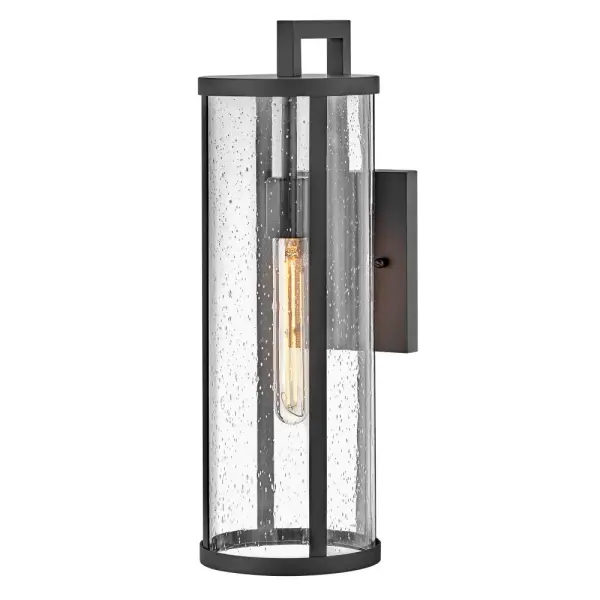 The Alfie wall lantern combines timeless cylindrical form with clear seedy glass for a versatile outdoor lighting solution. Its medium scale and transitional styling complement various architectural styles while the textured glass adds visual interest.