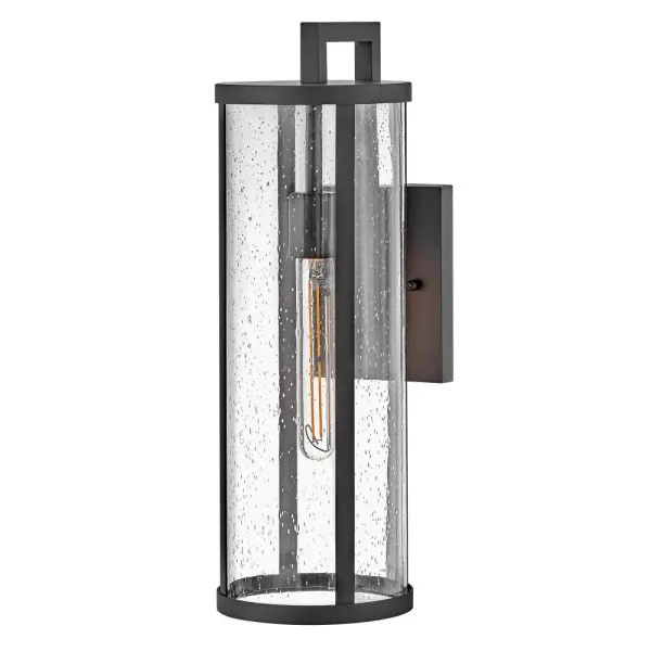 The Alfie wall lantern combines timeless cylindrical form with clear seedy glass for a versatile outdoor lighting solution. Its medium scale and transitional styling complement various architectural styles while the textured glass adds visual interest. - alternate view