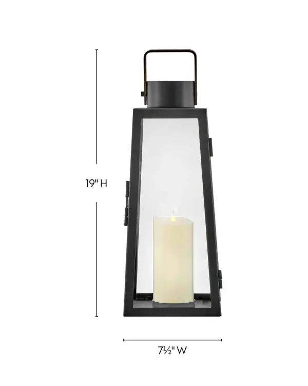 The Hugh Decorative Lantern combines bold trapezoidal design with oversized clear glass panes and a sleek black metal frame. Battery-operated LED faux flame candle included for versatile placement without wiring. - alternate view
