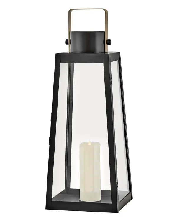 The Hugh Large Decorative Lantern combines bold trapezoidal design with over-scaled clear glass panes and a sleek metal frame. Battery-operated LED faux flame candle included for cordless convenience indoors or out.