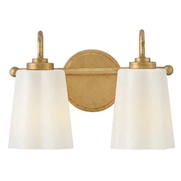 The Honey vanity light combines softly flowing cased opal glass with a distressed brass finish for a charming, versatile look. Its compact 13.25-inch width makes it ideal for smaller bathrooms while providing ample illumination.