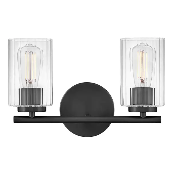 The Leta vanity light combines clear ribbed glass with a sleek Black finish to create a sophisticated bathroom lighting solution. Its compact 13.75-inch width makes it perfect for smaller vanities while delivering ample illumination.