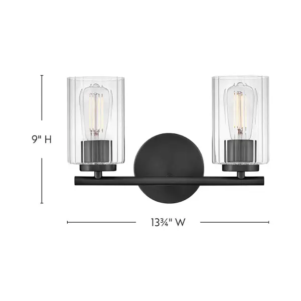 The Leta vanity light combines clear ribbed glass with a sleek Black finish to create a sophisticated bathroom lighting solution. Its compact 13.75-inch width makes it perfect for smaller vanities while delivering ample illumination. - alternate view