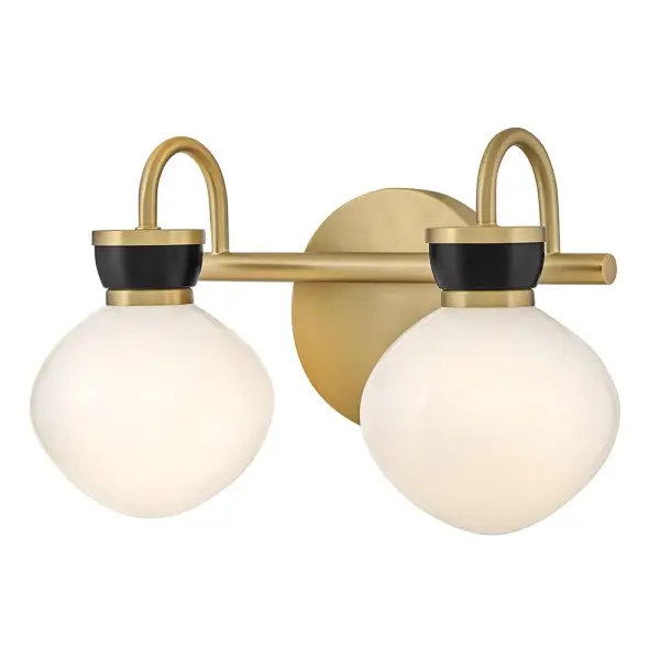 The Lucy vanity light combines classic schoolhouse glass shades with contemporary brass and black accents, creating a petite fixture that delivers both style and function for smaller bathroom spaces.