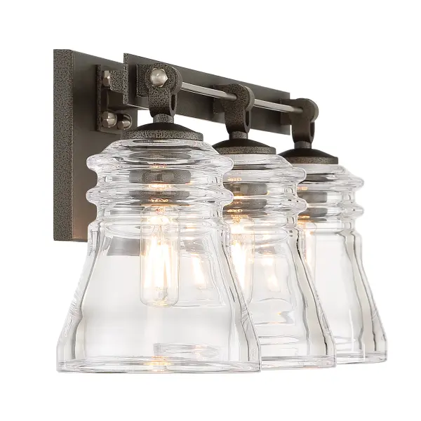 The Graham Avenue bath vanity combines traditional styling with industrial accents through its smoked iron and brushed nickel finish. Clear pressed glass shades provide excellent task lighting for bathroom vanities. - alternate view
