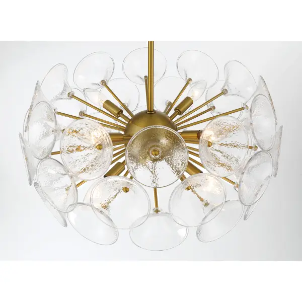 The Winter chandelier brings contemporary sophistication with its 22-inch linear design and soft brass finish. Eight candelabra bulbs illuminate through textured clear fluted glass shades, creating beautiful light diffusion perfect for dining spaces. - alternate view