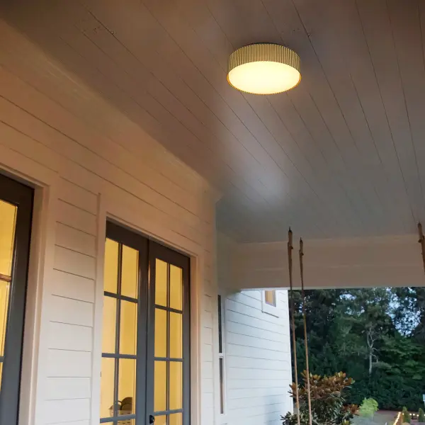 The Channel 9" Flush Mount combines Art Deco-inspired fluted detailing with modern LED technology. Its black and brass finish adds sophisticated contrast, while the white glass diffuser provides soft, even illumination. - alternate view
