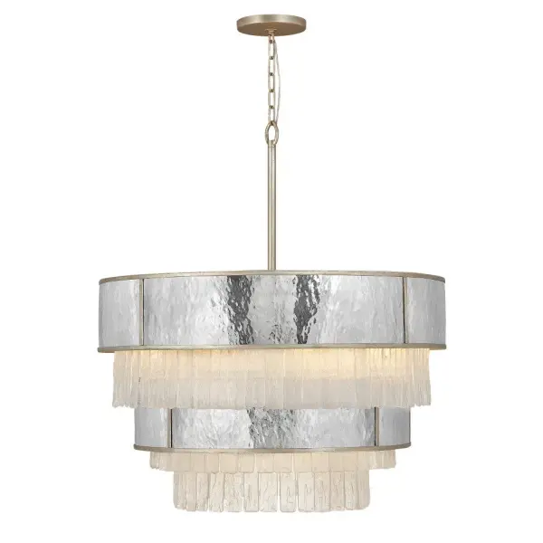 The Reverie chandelier combines hammered stainless steel with textured crystal accents for a luxurious transitional statement. Its 32-inch diameter and multi-tier design create dramatic visual impact perfect for formal spaces.