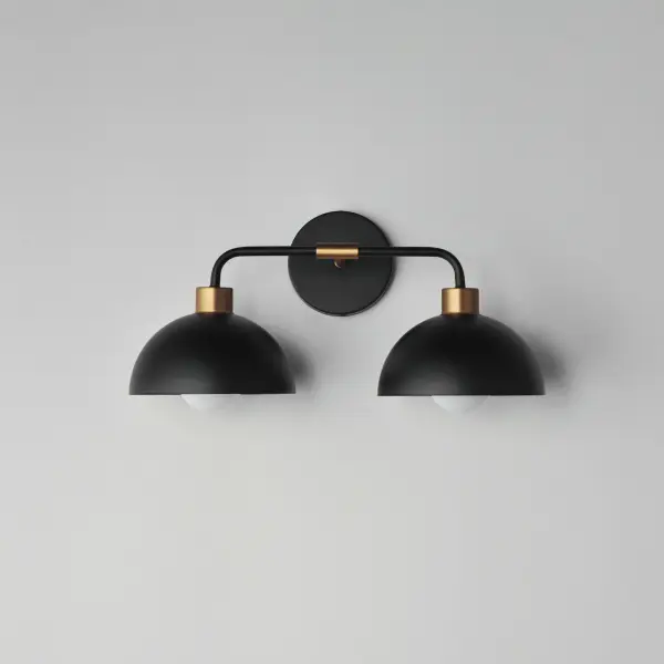 Dome shaped shades in Matte Black contrast Natural Aged Brass accents. Available in flush mount, bath vanity, and swing arm wall sconce configurations. This collection delivers an approachable, modern design that pairs well with transitional design aesthetics. - alternate view