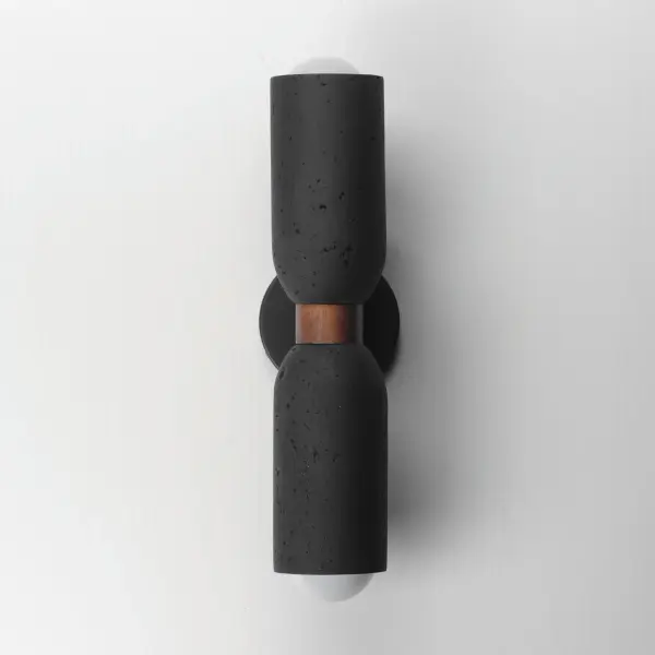 A tribute of natural materials, this collection features carved stone shades in your choice of Travertine or volcanic Lava Rock, paired with coordinating lathed wood bases. The Travertine composition showcases White Oak wood and Ecru white metal accents, while the blackened Lava Rock is beautifully complemented by Walnut wood and a Matte Black finish. Available in versatile pendant and wall sconce configurations, each piece highlights the organic beauty and timeless sophistication of its materials. - alternate view