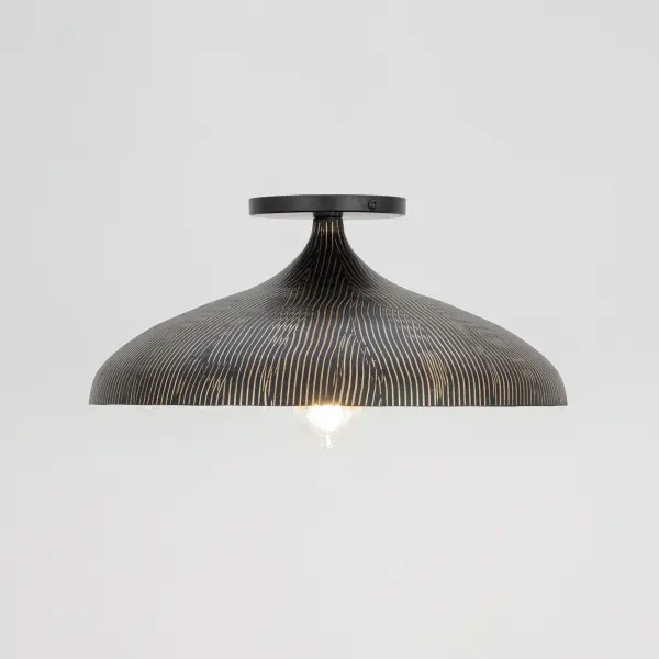 Graceful and sculptural, Fleur's gently flared silhouette brings a sense of quiet sophistication to any space. Hand-spun metal shades are adorned with a striated finish, scraped by hand to reveal glowing Gold undertones beneath layers of Matte Black or White. A matching Gold interior warms the light within, while a coordinating fabric cord suspends them for convenient height adjustments. Offered in multiple pendant sizes and a flush mount, Fleur offers tailored elegance to interior spaces such as entries and over a kitchen island. - alternate view
