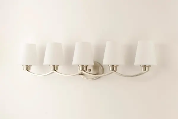 Graceful arcs of rectangular tubing transition to round cups that support tapered Satin White glass shades creating a crisp and clean transitional design. The frame is finished in your choice of Satin Nickel or Black which bridges modern and transitional design aesthetics. Collection: Shelter Finish: Satin Nickel Glass: Satin White Width: 37.50" Height: 9.50" Length: 6.50" Weight: 6.71 lb Extension from Wall: 6.50" Wire: 10" Canopy: 4.5"x7" Number of Bulbs: 5 Maximum Wattage: 60.00 W Bulb Type: A19 Bulb Base: E26 Medium Light Source: Incandescent Dimmable Voltage: 120.00 V Material: Steel, Glass Safety Listing: cULus Safety Rating: Damp Manufacturer Warranty: 1 Spec Sheet Instructions Parts Diagram - alternate view