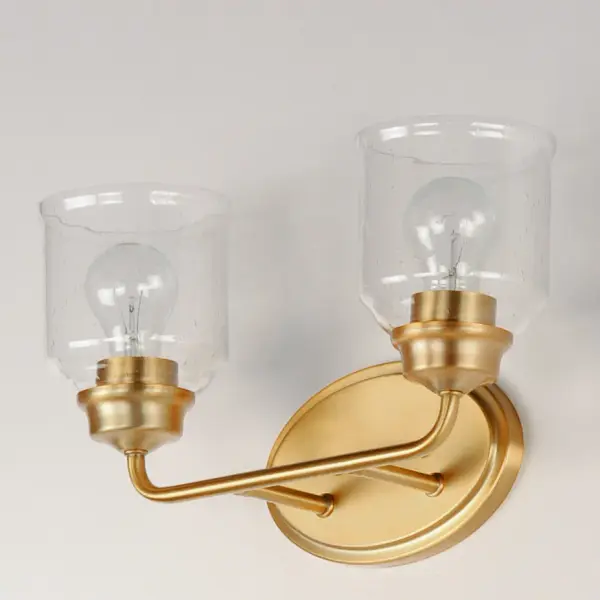A modest frame of steel tubing gently bends to support a cluster of Clear Seedy bell-shaped glass. Similarly the bobeches and other metal accents echo that traditional bell shape creating an instant classic. An easy choice with transitional appeal, choose from a variety of complimentary finishes including matte Black, Heritage Brass or Satin Nickel. Collection: Acadia Finish: Heritage Glass: Seedy Width: 14.75" Height: 9.00" Weight: 2.95 lb Extension from Wall: 6.50" Wire: 8" Canopy: 5"x8" Number of Bulbs: 2 Maximum Wattage: 60.00 W Bulb Type: E26 Bulb Base: E26 Medium Light Source: Incandescent Dimmable Voltage: 120.00 V Material: Steel + Glass Safety Listing: cETLus Safety Rating: Damp Manufacturer Warranty: 1 Spec Sheet Instructions - alternate view