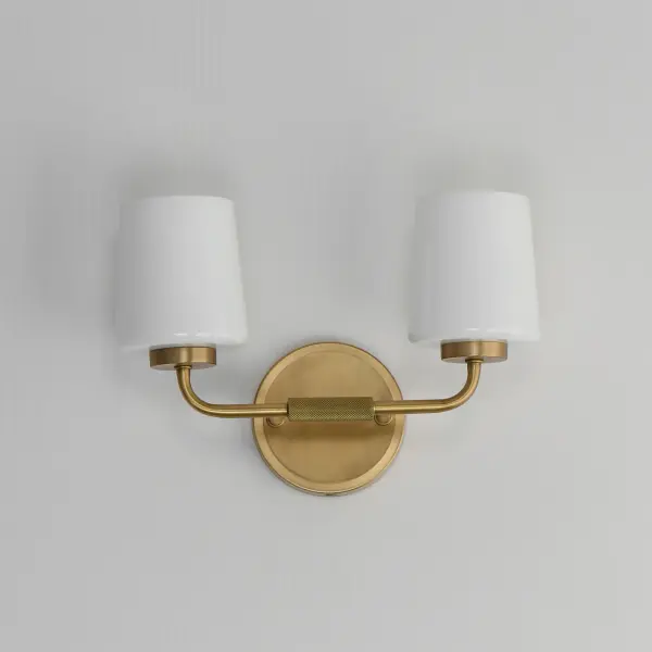 Featuring knurled rod details, this lighting collection brings a modern industrial edge to any space. Available in a range of sizes for chandeliers and two styles of bath vanity lighting, it offers versatility for different design needs. Offered in Matte Black, Satin Nickel, and Natural Aged Brass, this collection complements a wide variety of interior styles. Collection: Durham Finish: Natural Aged Brass Glass: White Width: 13.75" Height: 9.25" Weight: 4.20 lb Extension from Wall: 5.50" Wire: 8" Canopy: 5"x5" Number of Bulbs: 2 Maximum Wattage: 60.00 W Bulb Type: A19 Bulb Base: E26 Medium Light Source: Incandescent Dimmable Voltage: 120.00 V Material: Steel, Glass Safety Listing: cULus Safety Rating: Damp Spec Sheet Instructions - alternate view