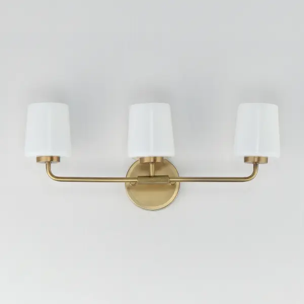 Featuring knurled rod details, this lighting collection brings a modern industrial edge to any space. Available in a range of sizes for chandeliers and two styles of bath vanity lighting, it offers versatility for different design needs. Offered in Matte Black, Satin Nickel, and Natural Aged Brass, this collection complements a wide variety of interior styles. Collection: Durham Finish: Natural Aged Brass Glass: White Width: 23.00" Height: 9.25" Weight: 6.00 lb Extension from Wall: 5.50" Wire: 8" Canopy: 5"x5" Number of Bulbs: 3 Maximum Wattage: 60.00 W Bulb Type: A19 Bulb Base: E26 Medium Light Source: Incandescent Dimmable Voltage: 120.00 V Material: Steel, Glass Safety Listing: cULus Safety Rating: Damp Spec Sheet Instructions - alternate view