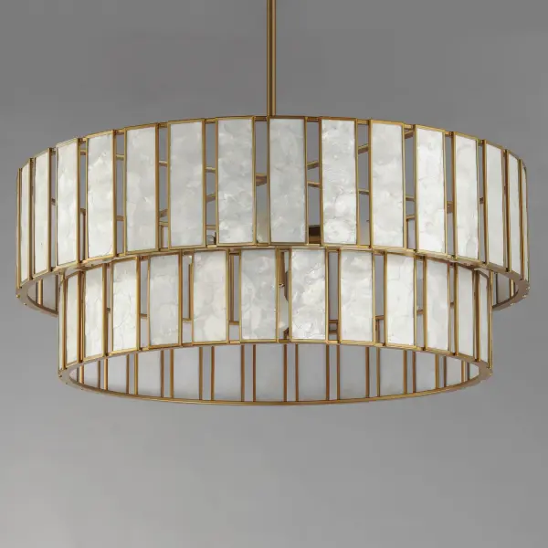 Classic in form and evoking the sea, laminae of Capiz shell are framed in paneled drum shapes. The Natural Aged Brass finish refines the coastal elements and complements the warm glow from behind the translucent panels. Available in multiple configurations of pendants as well as tiered chandeliers as well as a tall ADA-compliant wall sconce, the collection offers a sophisticated approach to coastal design. - alternate view