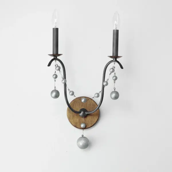This series draws inspiration from regal agrarian manors, delivering a statement in its scale and sophisticated finishes. Designed in operatic proportions, the bottom chandelier assembly features swollen curves hand painted in a choice of Ecru White or Golden Noir and suspended by a rigid hook structure replete with vintage charm. These finish combinations not only add dimension and interest, but they are enhanced with the contrastingly brighter accents against the rich, weathered finishes. Extended chain links with smoky beveled crystal charms drape the Ecru and Gold Leaf finish combination, while the darker Golden Noir variation features strands of patinaed silver wooden beads. Collection: Formosa Finish: Golden Noir Width: 12.00" Height: 21.50" Weight: 1.67 lb Extension from Wall: 7.00" Wire: 8" Canopy: 0.75"x5" Number of Bulbs: 2 Maximum Wattage: 60.00 W Bulb Type: B10 Bulb Base: E12 Candelabra Light Source: Incandescent Dimmable Voltage: 120.00 V Material: Steel, Wood Safety Listing: cETLus Safety Rating: Dry Spec Sheet Instructions - alternate view