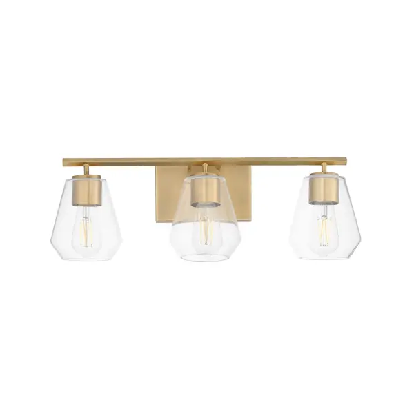 Crystalline clarity meets modern structure in the Geode collection. Inspired by the faceted symmetry of natural mineral formations, each clear glass shade is cut in an angular form that plays with light and shadow. The bold, geometric silhouette feels effortlessly architectural -- elevated further by subtle industrial notes like knurled screw collars and diamond shaped tubing on bath configurations. Offered in a range of sizes and finishes, Geode brings sculptural interest to kitchens, bathrooms, and dining rooms as well as statement-making entryways. Collection: Geode Finish: Natural Aged Brass Glass: Clear Width: 22.50" Height: 7.75" Weight: 4.40 lb Extension from Wall: 6.50" Wire: 8" Canopy: 4.75"x7" Number of Bulbs: 3 Maximum Wattage: 60.00 W Bulb Type: A19 Bulb Base: E26 Medium Light Source: Incandescent Voltage: 120.00 V Material: Steel, Glass Safety Listing: cULus Safety Rating: Damp Manufacturer Warranty: 3 Spec Sheet