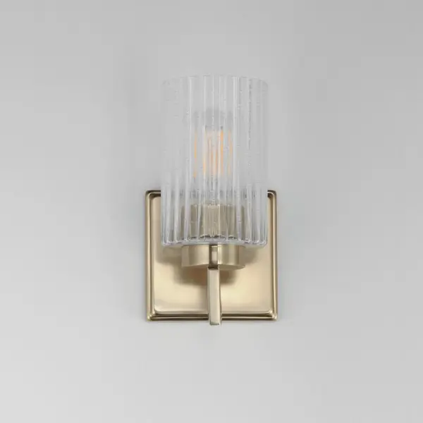 Clear Ribbed glass cylinders are supported on gracefully sweeping frames. The glass pattern helps to diffuse the light source while adding texture and style to the design. Available in Polished Nickel, Satin Champagne, or Matte Black. Collection: Rigata Finish: Satin Champagne Glass: Clear Ribbed Width: 5.00" Height: 9.00" Weight: 2.60 lb Extension from Wall: 5.75" Wire: 8" Canopy: 5"x5" Number of Bulbs: 1 Maximum Wattage: 60.00 W Bulb Type: A19 Bulb Base: E26 Medium Light Source: Incandescent Dimmable Voltage: 120.00 V Material: Steel, Glass Safety Listing: cULus Safety Rating: Damp Manufacturer Warranty: 3 Spec Sheet Instructions - alternate view
