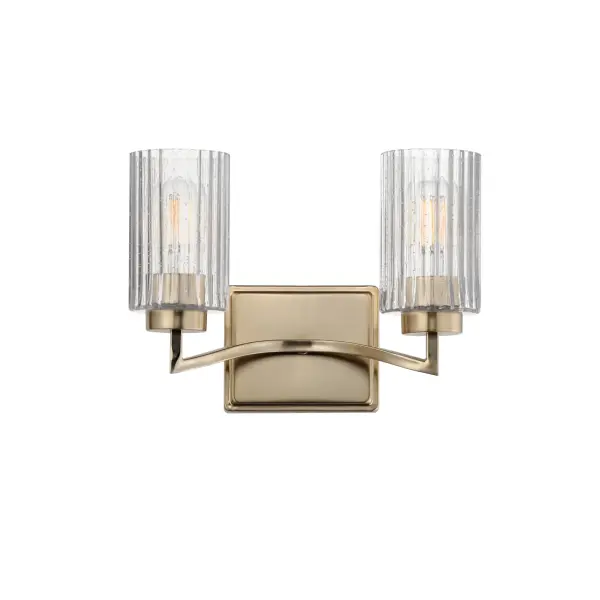 Clear Ribbed glass cylinders are supported on gracefully sweeping frames. The glass pattern helps to diffuse the light source while adding texture and style to the design. Available in Polished Nickel, Satin Champagne, or Matte Black. Collection: Rigata Finish: Satin Champagne Glass: Clear Ribbed Width: 13.75" Height: 9.25" Weight: 4.10 lb Extension from Wall: 6.25" Wire: 8" Canopy: 5"x6" Number of Bulbs: 2 Maximum Wattage: 60.00 W Bulb Type: A19 Bulb Base: E26 Medium Light Source: Incandescent Dimmable Voltage: 120.00 V Material: Steel, Glass Safety Listing: cULus Safety Rating: Damp Manufacturer Warranty: 3 Spec Sheet Instructions