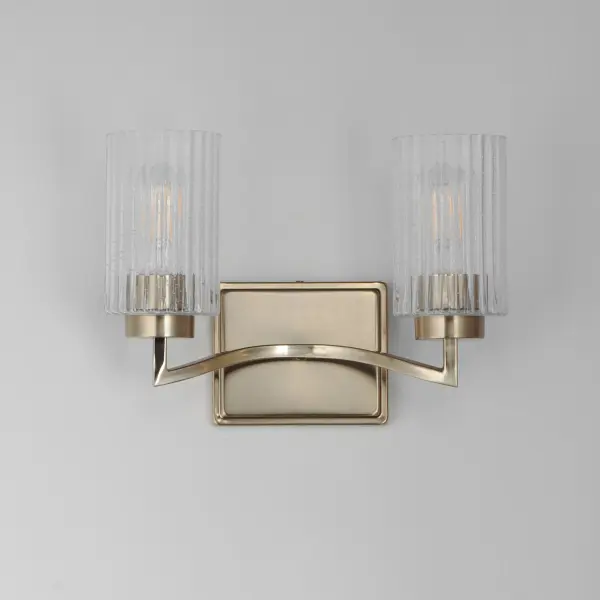 Clear Ribbed glass cylinders are supported on gracefully sweeping frames. The glass pattern helps to diffuse the light source while adding texture and style to the design. Available in Polished Nickel, Satin Champagne, or Matte Black. Collection: Rigata Finish: Satin Champagne Glass: Clear Ribbed Width: 13.75" Height: 9.25" Weight: 4.10 lb Extension from Wall: 6.25" Wire: 8" Canopy: 5"x6" Number of Bulbs: 2 Maximum Wattage: 60.00 W Bulb Type: A19 Bulb Base: E26 Medium Light Source: Incandescent Dimmable Voltage: 120.00 V Material: Steel, Glass Safety Listing: cULus Safety Rating: Damp Manufacturer Warranty: 3 Spec Sheet Instructions - alternate view