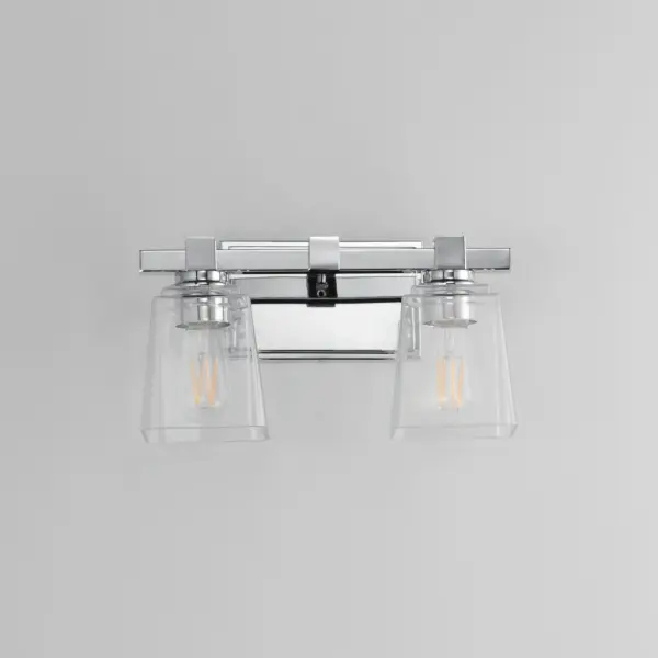 A composition of square forms that feature a Clear tapered square glass shade, these bath vanities provide a transitional design that suits both modern and traditional spaces. Available in Matte Black, Polished Chrome, Satin Nickel, and Natural Aged Brass. Collection: Cubos Finish: Polished Chrome Glass: Clear Width: 14.00" Height: 8.00" Weight: 4.10 lb Extension from Wall: 6.00" Wire: 8" Canopy: 4.75"x7.75" Number of Bulbs: 2 Maximum Wattage: 60.00 W Bulb Type: A19 Bulb Base: E26 Medium Light Source: Incandescent Dimmable Voltage: 120.00 V Material: Steel, Glass Safety Listing: cULus Safety Rating: Damp Manufacturer Warranty: 3 Spec Sheet Instructions - alternate view