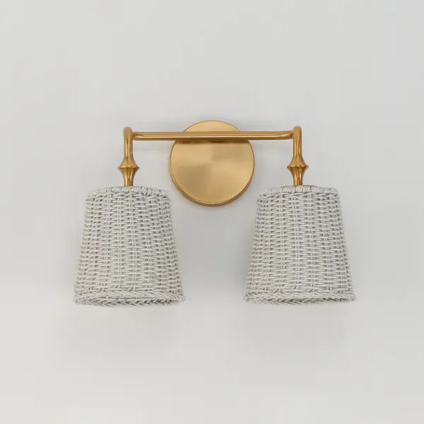 Featuring wicker shades made of synthetic rattan, this bath vanity lighting collection brings an elegant coastal flair to your space. Choose from a Natural wicker finish with a Dark Bronze frame accented by brushed golden highlights, or a Weathered White rattan with a Natural Aged Brass frame for a timelessly elegant composition. Collection: Baja Finish: Natural Aged Brass Width: 14.75" Height: 10.25" Weight: 3.00 lb Extension from Wall: 7.50" Wire: 8" Canopy: 4.75"x4.75" Number of Bulbs: 2 Maximum Wattage: 60.00 W Bulb Type: A19 Bulb Base: E26 Medium Light Source: Incandescent Dimmable Voltage: 120.00 V Material: Steel, Rattan Safety Listing: cULus Safety Rating: Damp Spec Sheet Instructions - alternate view
