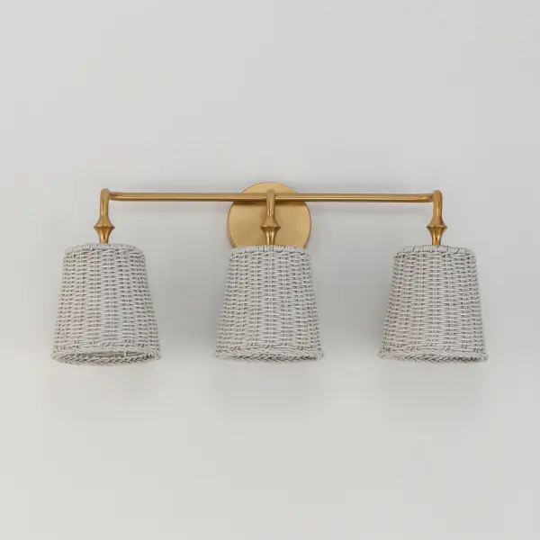 Featuring wicker shades made of synthetic rattan, this bath vanity lighting collection brings an elegant coastal flair to your space. Choose from a Natural wicker finish with a Dark Bronze frame accented by brushed golden highlights, or a Weathered White rattan with a Natural Aged Brass frame for a timelessly elegant composition. Collection: Baja Finish: Natural Aged Brass Width: 24.25" Height: 10.00" Weight: 3.90 lb Extension from Wall: 7.50" Wire: 8" Canopy: 4.75"x4.75" Number of Bulbs: 3 Maximum Wattage: 60.00 W Bulb Type: A19 Bulb Base: E26 Medium Light Source: Incandescent Dimmable Voltage: 120.00 V Material: Steel, Rattan Safety Listing: cULus Safety Rating: Damp Spec Sheet Instructions - alternate view