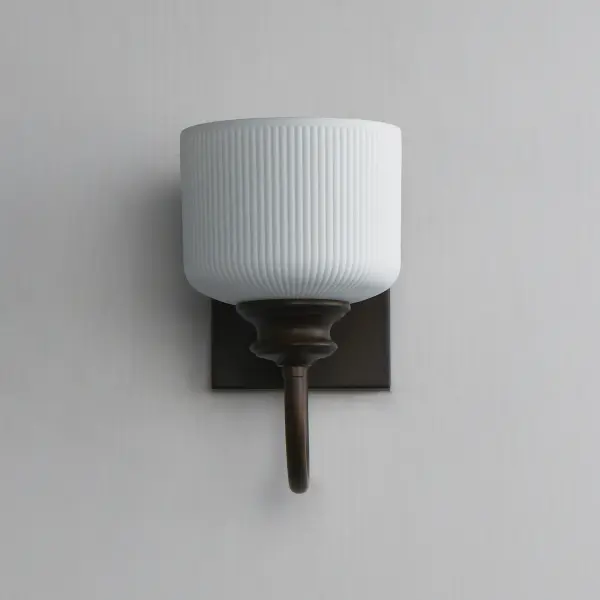 Ribbed ceramic shades are gracefully suspended on classic arching tube frames, creating a timeless yet modern design. The matte bisque-fired ceramic is translucent softly diffuses light while highlighting the ribbed raised pattern. Available in elegant finishes, choose from Natural Aged Brass, Oil Rubbed Bronze, or Polished Nickel frames to complement your space. Collection: Bisque Finish: Oil Rubbed Bronze Glass: White Width: 5.50" Height: 10.00" Weight: 2.20 lb Extension from Wall: 9.00" Wire: 8" Canopy: 6"x4.75" Number of Bulbs: 1 Maximum Wattage: 60.00 W Bulb Base: E26 Medium Light Source: Incandescent Dimmable Voltage: 120.00 V Material: Steel, Glass Safety Listing: cETLus Safety Rating: Damp Spec Sheet Instructions - alternate view