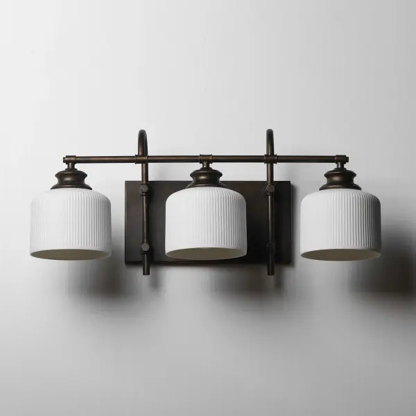 Ribbed ceramic shades are gracefully suspended on classic arching tube frames, creating a timeless yet modern design. The matte bisque-fired ceramic is translucent softly diffuses light while highlighting the ribbed raised pattern. Available in elegant finishes, choose from Natural Aged Brass, Oil Rubbed Bronze, or Polished Nickel frames to complement your space. Collection: Bisque Finish: Oil Rubbed Bronze Glass: White Width: 24.00" Height: 10.00" Weight: 6.38 lb Extension from Wall: 9.00" Wire: 8" Canopy: 6"x12" Number of Bulbs: 3 Maximum Wattage: 60.00 W Bulb Base: E26 Medium Light Source: Incandescent Dimmable Voltage: 120.00 V Material: Steel, Glass Safety Listing: cETLus Safety Rating: Damp Spec Sheet Instructions - alternate view