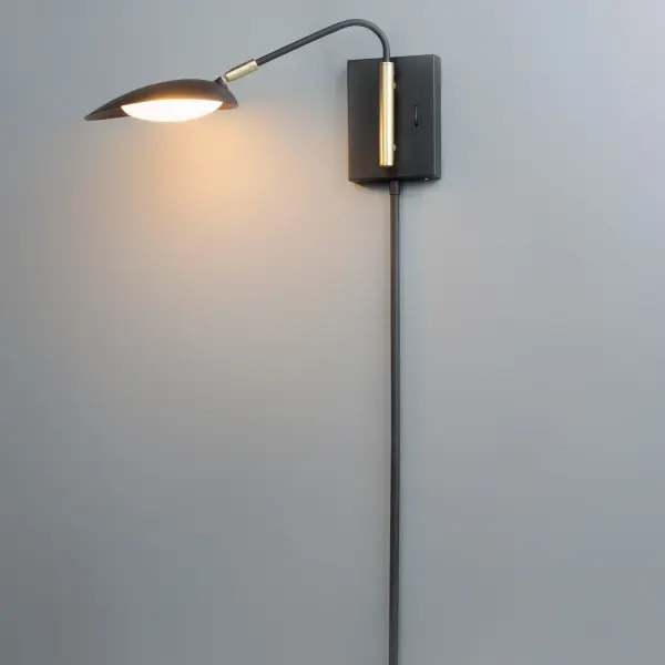Inspired by Mid-Century Modern design, this collection features tapered hoods that conceal LED modules that can be adjusted to direct the light. The Black finish with contrasting Satin Brass accents softens the look to work in a broader range of design. The wall pin up lamps work great at bedside while the floor lamp version is at home next to a chair. - alternate view