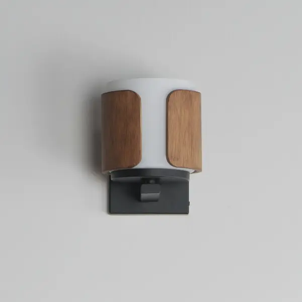 Inspired by the precision and artistry of classic millwork, Draughtsman fuses refined materials with a tailored silhouette to deliver an elevated lighting solution rooted in craftsmanship. Sculpted wood panels form an open cylindrical frame, flared slightly at the base for a gentle curve that evokes artisan joinery. A Satin White glass diffuser softly disperses light downward, grounding the form with warmth and clarity. Offered in two finish combinations--rich Walnut with matte Black or Whitewashed Oak with Charcoal--this collection brings a handsome, architectural touch to transitional and traditional interiors alike. - alternate view