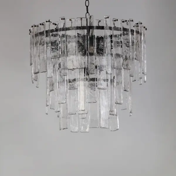 Gracefully flowing molten glass panels with uniquely organic aesthetic encircle rings of rich Darkened Bronze metal or hand-applied Gold Leaf. This refined interpretation of tiered glass pendants exudes warmth and elegance, effortlessly blending a moody ambiance with timeless contemporary charm. Available in a variety of pendant configurations as well as coordinating wall sconce and semi-flush mount. - alternate view