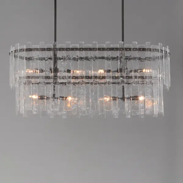 Gracefully flowing molten glass panels with uniquely organic aesthetic encircle rings of rich Darkened Bronze metal or hand-applied Gold Leaf. This refined interpretation of tiered glass pendants exudes warmth and elegance, effortlessly blending a moody ambiance with timeless contemporary charm. Available in a variety of pendant configurations as well as coordinating wall sconce and semi-flush mount. - alternate view